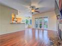 Open-concept living room featuring wood floors, ceiling fan, and access to the backyard at 401 Obsidian St, Las Vegas, NV 89145