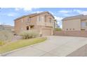 Two-story stucco home featuring an attached two-car garage and a long driveway with adjacent green space at 482 Painted Sage Ct, Henderson, NV 89015