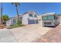 Two-story home with a two-car garage, a well-manicured lawn, and an RV parked in the driveway at 4871 La Princesa Ct, North Las Vegas, NV 89031