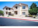 A two-story condo building with red tile roofing and well-maintained landscaping at 520 Arrowhead Trl # 1322, Henderson, NV 89015