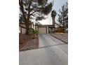 Inviting single-story house with a paved driveway, desert landscaping, and a simple, clean facade at 542 Grimsby Ave, Henderson, NV 89014