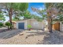 Cozy single-story home showcasing neutral paint, gravel landscaping, mature trees, and a two-car garage at 542 Grimsby Ave, Henderson, NV 89014