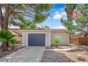 Inviting single-story home with desert landscaping and a blue two-car garage door at 542 Grimsby Ave, Henderson, NV 89014