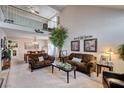 Spacious living room featuring vaulted ceilings, a decorative tree, and a seamless flow into the dining area at 7109 Deepriver Cir, Las Vegas, NV 89129