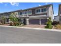 Beautiful home featuring a three-car garage, stone accents, neutral paint, and manicured landscaping at 7260 Grace Estate Ave, Las Vegas, NV 89113