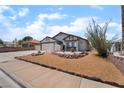 Charming single-story home with a two-car garage and desert landscaping in the front yard at 806 Fireweed Dr, Henderson, NV 89002