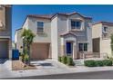 Two-story home with a beige stucco exterior, a blue front door, and an attached one-car garage at 9140 Entrancing Ave, Las Vegas, NV 89149