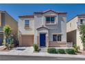 Charming two-story home featuring a blue door, a front porch, and a single-car garage at 9140 Entrancing Ave, Las Vegas, NV 89149