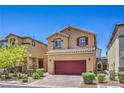 Charming two-story home features a red garage door, brick driveway, and well-maintained landscaping at 9229 Brayden Bay St, Las Vegas, NV 89178