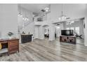 Open-concept living room boasts soaring ceilings, wood floors, and staircase to the second level at 9585 Teton Diablo Ave, Las Vegas, NV 89117