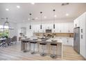 Open kitchen and dining area with a long island, modern cabinets, stainless steel appliances, and contemporary lighting at 10025 Netherton Dr, Las Vegas, NV 89134