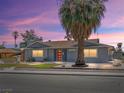 Inviting single-story home with a tidy front yard, red door, and a mature palm tree at 1700 E Oakey Blvd, Las Vegas, NV 89104