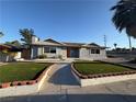 Lovely single-story home boasts a tidy front yard with lush faux grass and a tidy walkway at 1700 E Oakey Blvd, Las Vegas, NV 89104