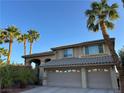 Inviting home featuring desert landscaping, a tile roof, and a spacious two-car garage, all bathed in natural light at 2440 Ping Dr, Henderson, NV 89074