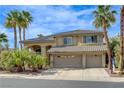 Stunning two-story home featuring a tile roof, three-car garage, and desert landscaping with palm trees at 2440 Ping Dr, Henderson, NV 89074