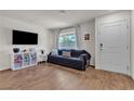 Bright living room with hardwood floors, large window and a cozy couch with throw pillows at 2598 Polar White Ave, North Las Vegas, NV 89086
