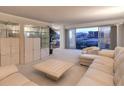 Bright living room with sleek furniture, display cases, and a sliding glass door to a balcony with a city view at 3111 Bel Air Dr # 23A, Las Vegas, NV 89109