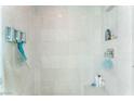 Bathroom shower boasts tiled walls, recessed shelving, and mounted dispensers at 322 Karen Ave # 2201, Las Vegas, NV 89109