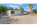 Side view of a home with white exterior, xeriscape landscaping, and a secure gate at 3320 Osage Ave, Las Vegas, NV 89101