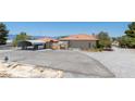 Single story home with an orange tile roof, covered parking, and basketball court at 3360 National Ave, Pahrump, NV 89048