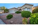 Well-maintained front yard with desert landscaping, mature trees, and a charming single-story home at 4005 Poppy Fields Dr, Las Vegas, NV 89129