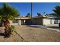 Cozy single-story home with a two-car garage and mature palm trees in the desert landscaped yard at 4354 Thorndale Pl, Las Vegas, NV 89103