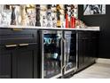 Custom wet bar with beverage center, black cabinetry and sleek hardware at 464 Beardsley Cir, Henderson, NV 89052