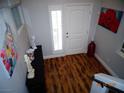 View of the home's entryway, featuring hardwood floors, art decor, and a front door with window at 5889 Thistle Meadow Ave, Las Vegas, NV 89139