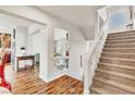 Open-concept foyer flows into living areas, accentuated by wood flooring and a staircase leading to the upper level at 5889 Thistle Meadow Ave, Las Vegas, NV 89139