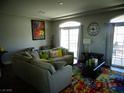 Spacious living room features a sectional sofa, large windows, and a decorative colorful area rug at 5889 Thistle Meadow Ave, Las Vegas, NV 89139