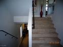 Carpeted staircase with dark wood railing leading to the upper level of the home at 5889 Thistle Meadow Ave, Las Vegas, NV 89139
