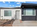 Single story home with a mix of white and black brick exterior and easy to maintain gravel landscaping at 704 Slayton Dr, Las Vegas, NV 89107