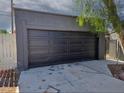 View of the detached one car garage with a black garage door and concrete driveway at 709 Evergreen Cir, Las Vegas, NV 89107