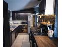 Features of this kitchen include stainless steel appliances, black cabinets, tile floors, and tiled backsplash at 709 Evergreen Cir, Las Vegas, NV 89107