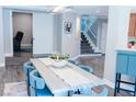 Dining area showcases open floor plan, adjacent to staircase, accented by modern light fixture and gray laminate flooring at 7607 Boca Raton Dr, Las Vegas, NV 89113
