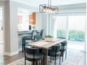 Inviting dining area with modern light fixture, bar seating, and sliding glass doors to a private backyard at 7607 Boca Raton Dr, Las Vegas, NV 89113