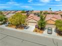 Charming single-story home with desert landscaping, mature trees, and a two-car garage at 7669 Fieldfare Dr, North Las Vegas, NV 89084
