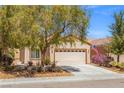 Inviting home with mature landscaping, a two-car garage, and a charming American flag at 7669 Fieldfare Dr, North Las Vegas, NV 89084