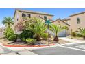 Lovely home exterior with desert landscaping, lush green shrubs, and a two-car garage at 7724 Somerhill Point Way, Las Vegas, NV 89139