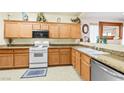 Well-maintained kitchen featuring wood cabinets, granite countertops, and modern appliances at 7724 Somerhill Point Way, Las Vegas, NV 89139