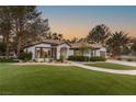 Charming single-story home with lush, green landscaping and a two-car garage on a sunny day at 9029 Rivers Edge Dr, Las Vegas, NV 89117