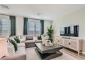 Comfortable living room with a large sectional sofa, modern coffee table, and tasteful décor, perfect for relaxation at 9564 Archer Peak Ct, Las Vegas, NV 89143