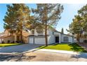 Charming two-story home with a well-manicured lawn, mature trees, and a three-car garage at 9937 Whalers Landing Ct, Las Vegas, NV 89117
