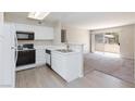 Bright kitchen with white cabinets and appliances, opening to a sunny living space at , Las Vegas, NV 89120