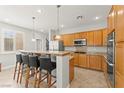 Bright kitchen with stainless steel appliances, a breakfast bar with seating, and ample wood cabinetry at 11274 Civita St, Las Vegas, NV 89141
