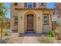 Close up exterior featuring a landscaped front yard with an arched entryway and a brown front door at 1130 Blissful Plains Ave, North Las Vegas, NV 89086
