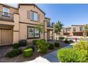 Desirable townhome showcasing manicured landscaping, a brick walkway, and charming architectural details at 1200 Mission View Ct, Henderson, NV 89002