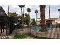 Apartment complex pool area with fence, palm trees, and shade at 1405 Vegas Valley Dr # 360, Las Vegas, NV 89169