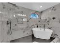 Luxurious bathroom featuring a marble shower and free standing tub with black fixtures at 1611 Buffalo Trail Dr, Henderson, NV 89014