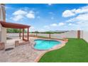 Inviting backyard featuring a sparkling pool, lush landscaping, and a covered patio area for outdoor entertaining at 1611 Buffalo Trail Dr, Henderson, NV 89014